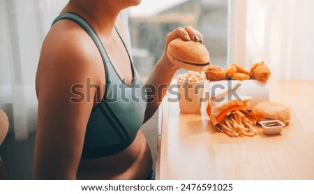 Binge eating disorder concept with woman eating fast food burger, fired chicken , donuts and desserts