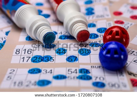 Bingo cards with red and blue markers close up