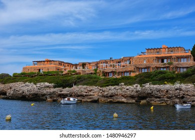Binibecca,Menorca/Spain-May 22,2019 :  The orage stone bricks and sea view luxury villa locating on the cape of Binibecca vell amongst the calm ocean
