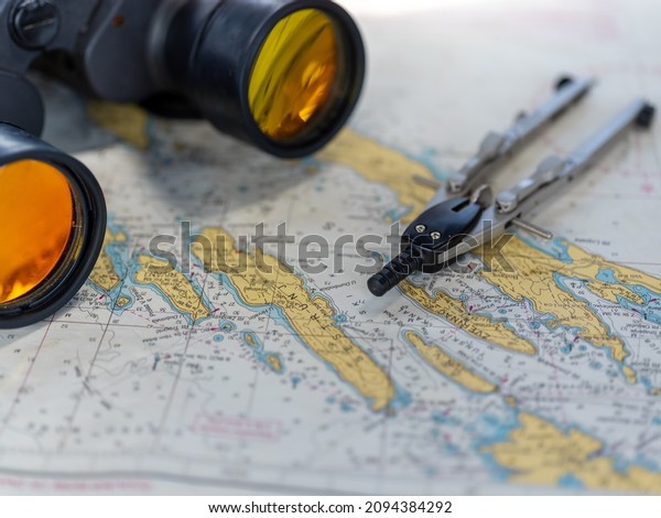 \
Binoculars and compasses on map for navigation\
on sailing ship, old navigation\
tools\
