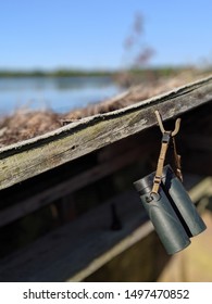 Binoculars Hanging In A Wooden Duck Hunting Blind With Water Background.