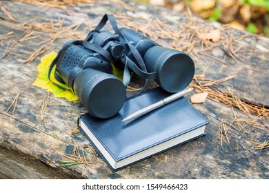 Binoculars with notebook and pencil.Explorer and adventure concept
