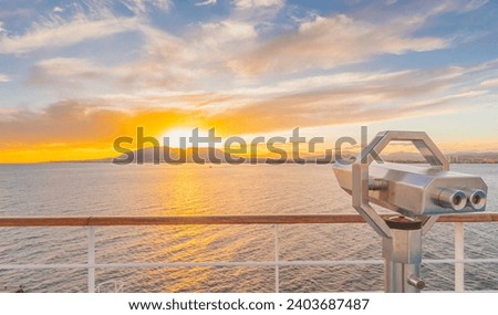 Binoculars on the deck of a cruise ship as it sails off into the sunset.