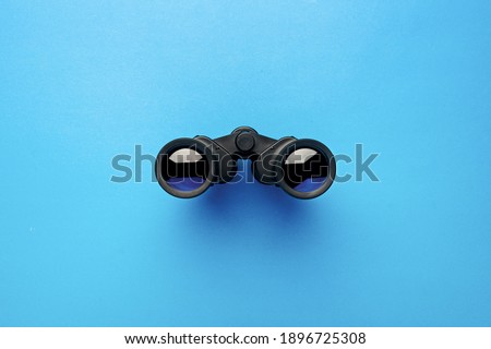 Binoculars on a light blue background. Banner. Flat lay, top view.