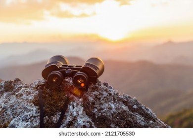 Binoculars On Top Of Rock Mountain At Sunset