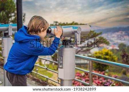 Binoscope. Stationary city binoculars. A boy looks at the city through a binoscope