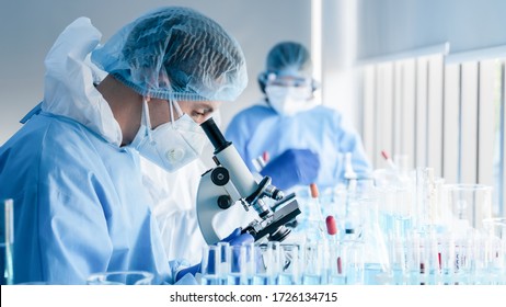 biochemical research scientist team working and microscope for coronavirus vaccine development in pharmaceutical research labolatory  selective focus