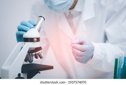 biochemical research scientist working with microscope for coronavirus, laboratory glassware containing chemical liquid for design or decorate science, chemistry, biology, medicine and people concept  - Powered by Shutterstock