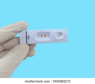 Biochemist or Lab Technologist holds a Device of Coxsackievirus A16 rapid screening test. Device Test showing positive result in the laboratory background. 
