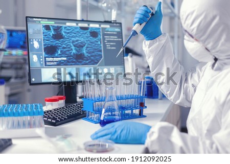 Biochemist man taking sample of liquid holding automatic pipette .Chemist in modern laboratory doing research using dispenser during global epidemic with covid-19. ストックフォト © 