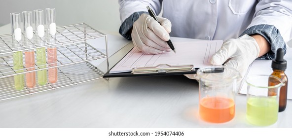 Biochemistry laboratory research, Chemist is analyzing sample in laboratory with equipment and science experiments glassware containing chemical liquid.