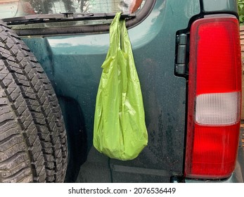 Biodegradable Dog Poop Bag Hanging On The Rear Windscreen Wiper Of A Car.