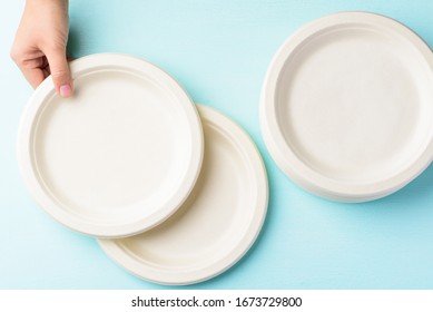 Biodegradable plate, Compostable plate or Eco friendly disposable plate holding by hand on pastel color background, top view
