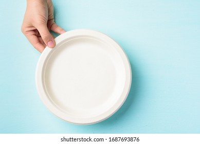 Biodegradable Plate, Compostable Plate Or Eco Friendly Disposable Plate Holding By Hand On Pastel Color Background, Top View