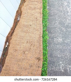 Biodegradable Soil Erosion Control Blanket Is Placed On The Strip Of Turf Area Outside The Perimeter Fence Hoarding To Stabilize And Reinforce Soil In A Construction Area Along Sidewalk. 