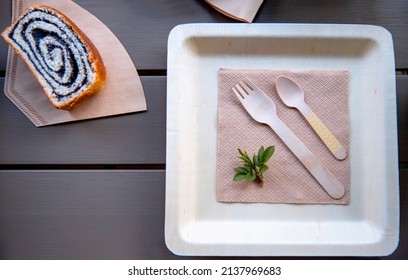 Biodegradable Square Plate With Wooden Cutlery And Poppy Seed Strudel On Bamboo Napkin, Ecological Table Set For One 