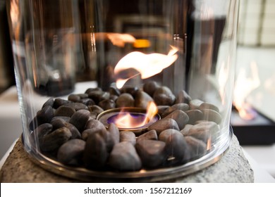 Bioethanol Fueled Portable Fireplace Burning At Home, For Live Fire At Home, No Chimney And Mantelpiece Is Needed. Liquid Bio Ethanol Burns In Cup. Round Shaped Glass With Stones Inside