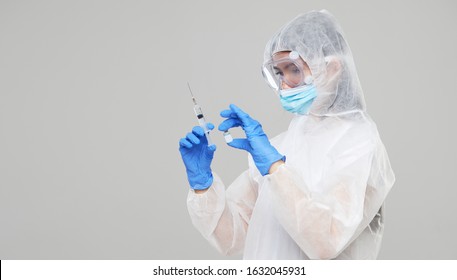 Biological hazard. Epidemic of the Chinese coronavirus. An asian woman in a protective suit and mask holds an injection syringe and vaccine. Vaccine from, flu, coronavirus, ebola, TB.  - Shutterstock ID 1632045931