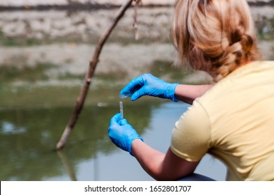 Biologist Taking A Water Sample. Student Biology Taking And Testing Sample Of Natural River Water. Experts Science Men Keep Water For Research Analysis In The Laboratory. Environmental Pollution Conce