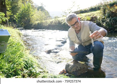 Biologist Testing Water Quality Of River