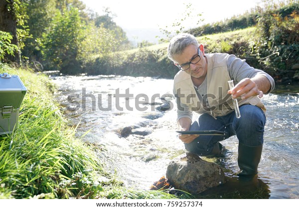 Biologist testing water\
quality of river