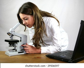 A biology student uses her microscope and laptop computer
