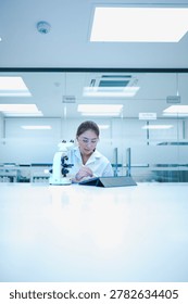 Biomedical researcher documenting microscopic validation results on electronic lab notebook. Quality control analyst auditing experimental data integrity via digital tool.