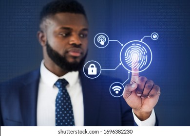 Biometric Authentication. African American Businessman Touching Virtual Panel For Fingerprint Scanning Over Blue Background. Selective Focus