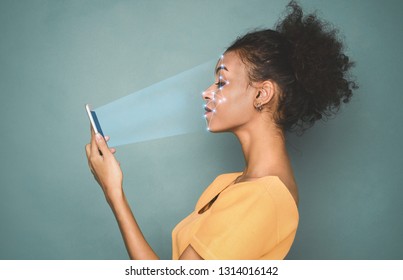 Biometric identification. African-american woman scanning face with facial recognition system on smartphone - Powered by Shutterstock