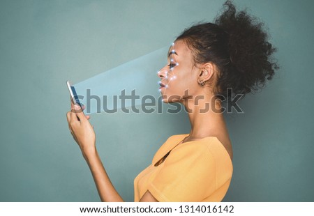 Biometric identification. African-american woman scanning face with facial recognition system on smartphone
