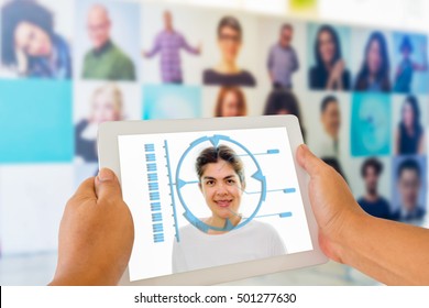 Biometric Verification, Face Recognition System Concept. Hand Holding Tablet With Female Face On Facial Recognition Software On Screen Against Blur Various Photo Frames Background.