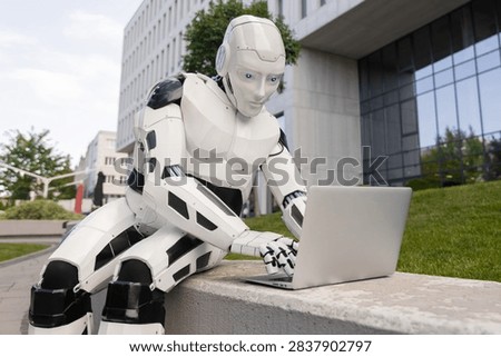 Bionic android operating laptop computer in front of glass office exterior