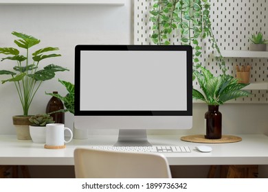 Biophilia workspace in home office room with computer, supplies, decorations and plants house - Shutterstock ID 1899736342
