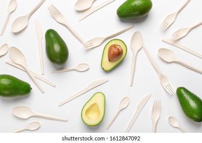 Bioplastic - Great alternative to plastic single use cutlery. Halves of avocado and eco disposable tableware isolated on white background