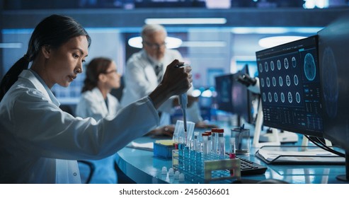 Biotechnology Research Laboratory: Female Asian Doctor Working With Test Tubes To Study Effect Of Innovative Alzheimer's Medicine. Focus Shifting To Colleagues Discussing CT Brain Scans On Computer. - Powered by Shutterstock