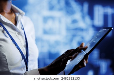 BIPOC computer operator writes code on tablet to visualize artificial intelligence neural networks using augmented reality. High tech workplace executive runs AI script for information processing