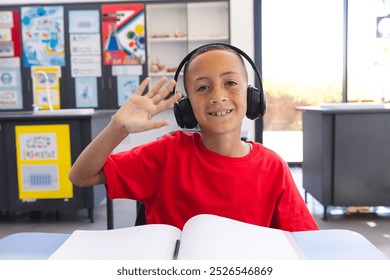 Biracial boy enjoys a learning session at school on a video call. He engaged with his studies while using headphones to focus. - Powered by Shutterstock