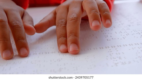 Biracial boy's hands are reading Braille text, with copy space. Close-up view captures the educational moment at school. - Powered by Shutterstock