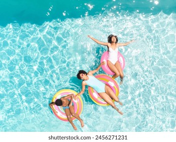 Biracial couple enjoys a sunny day in the pool, with copy space. Their joyful expressions capture the essence of a relaxing summer day outdoors. - Powered by Shutterstock