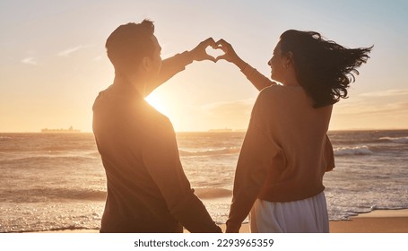 Biracial couple holding their hands together in a heart shape at the beach. Biracial couple holding their hands together in a heart shape at the beach. - Powered by Shutterstock