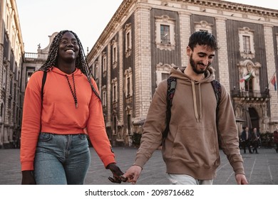 Biracial couple of young people walking in the city center holding hands - Powered by Shutterstock