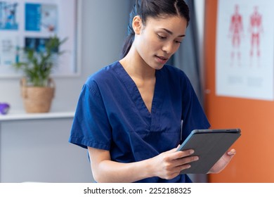 Biracial female physiotherapist using tablet in hospital therapy room, copy space. Hospital, medical and healthcare services. - Powered by Shutterstock