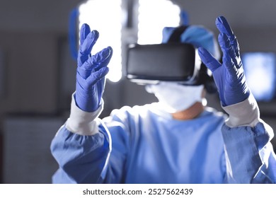 Biracial female surgeon wearing surgical gown using vr headset in operating theatre. Medicine, healthcare, surgery, technology, work and hospital, unaltered. - Powered by Shutterstock