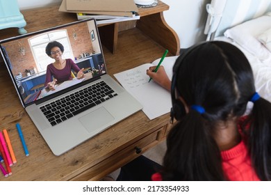 Biracial girl writing english while african american woman teaching online over video call on laptop. Unaltered, childhood, wireless technology, education, student and e-learning concept. - Powered by Shutterstock
