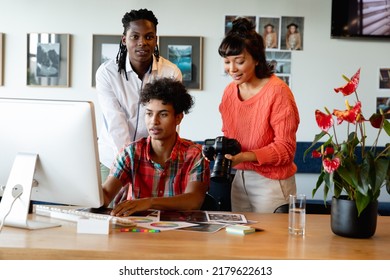 Biracial Photographer By Multiracial Colleagues Discussing Over Computer In Meeting At Office. Unaltered, Creative Business, Meeting, Teamwork, Diversity, Photography Themes.