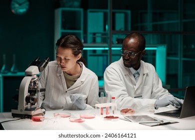 Biracial scientists working in team on synthetic meat alternative sitting at their workplace in lab - Powered by Shutterstock