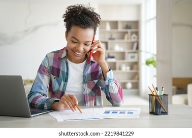 Biracial Teen Girl School Student Talking On Phone Discusses Homework With Friend. Smiling Schoolgirl, Sitting At Desk With Laptop, Making Call, Having Mobile Conversation While Learning At Home.