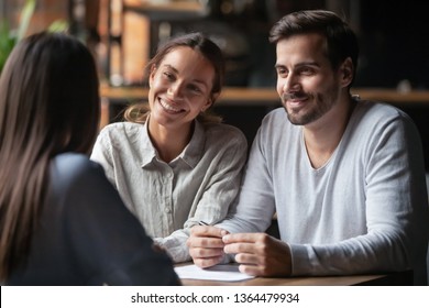 Biracial woman caucasian man listen vacancy candidate sitting together at table at job interview. Diverse couple communicating with real estate agent, successful meeting ready to sign contract concept - Powered by Shutterstock