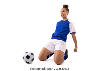 Biracial young female soccer player shouting while kneeling by soccer ball against white background. unaltered, sport, sports uniform, copy space, victory, athlete and women's soccer. - Powered by Shutterstock