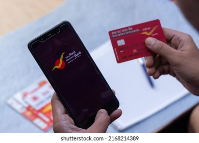 Birbhum, West Bengal, India - 25 April 2022: Top View Of A Smart Phone With IPPB Application And A Post Office Debit Card Held In Hand